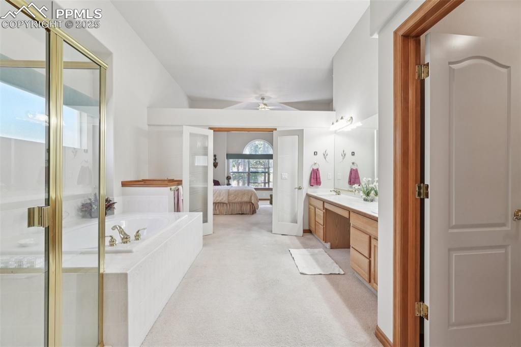 Image 28 of 45: Ensuite bathroom with double vanity, a garden tub, a shower stall, and a ce