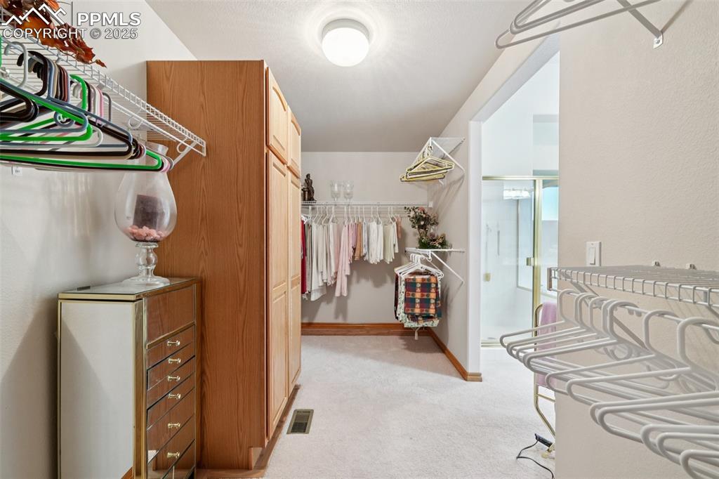 Image 29 of 45: Walk in closet with light colored carpet