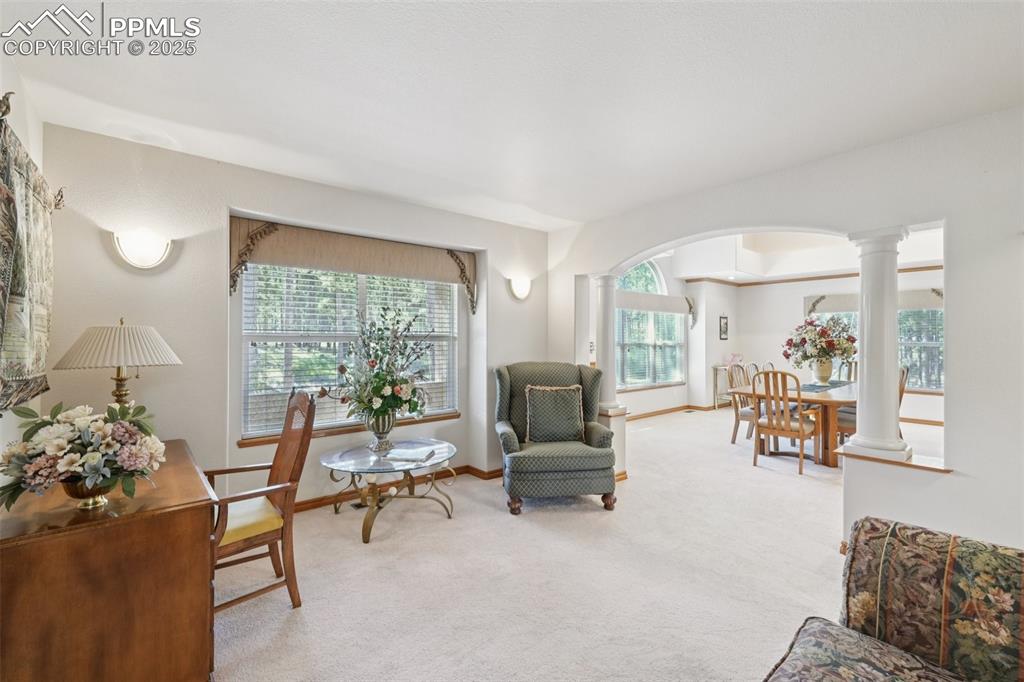 Image 6 of 45: Sitting room featuring ornate columns, arched walkways, and carpet