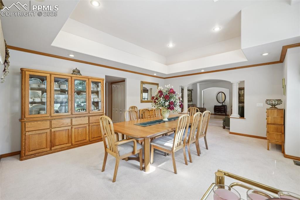 Image 8 of 45: Dining space with ornate columns, light carpet, arched walkways, recessed l