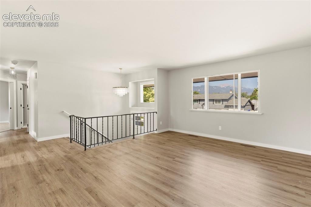 Image 10 of 46: Spacious interior featuring luxury vinyl plank flooring and Pikes Peak view