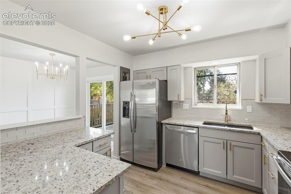 Image 17 of 46: Kitchen featuring light-toned cabinetry, light granite-style countertops, a