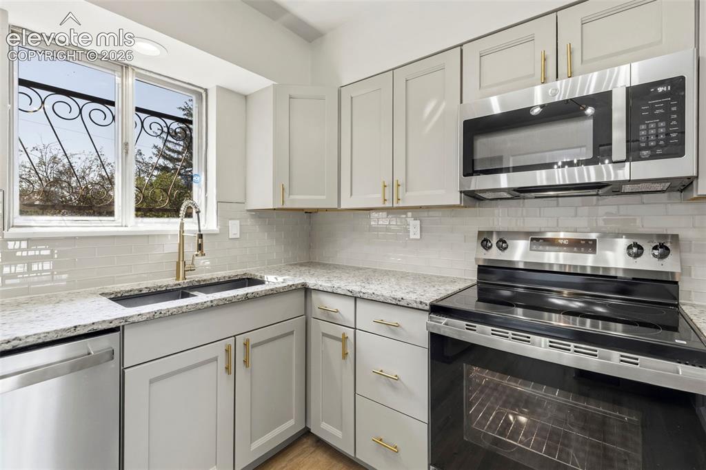 Image 18 of 46: Kitchen featuring light cabinetry, stainless steel appliances, granite-styl