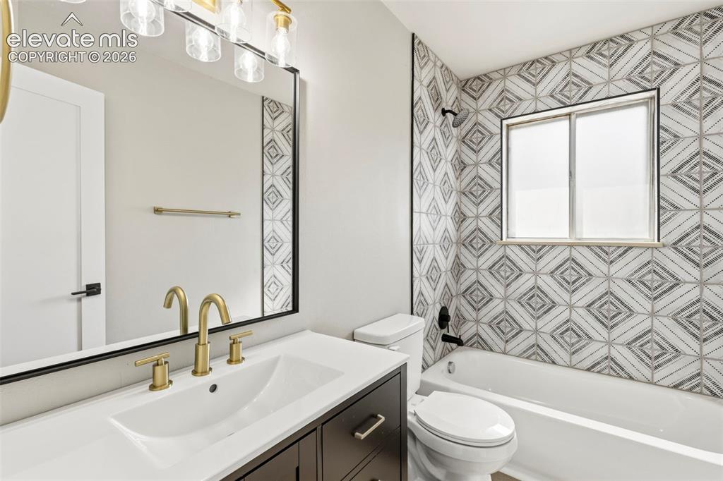 Image 24 of 46: Bathroom featuring a dark wood-finish vanity with a white countertop and un