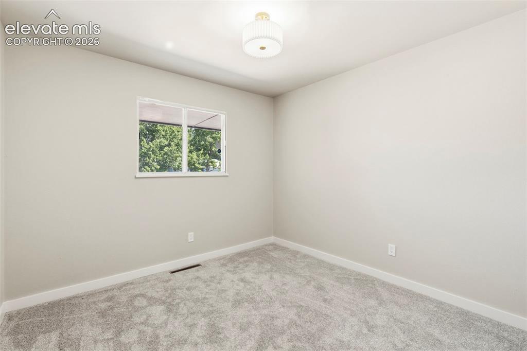 Image 30 of 46: Room featuring light gray wall paint, taupe carpeting, and white baseboards