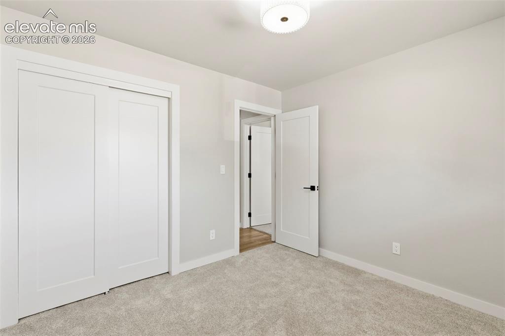 Image 32 of 46: Carpeted room featuring a white ceiling, light gray walls, white baseboards