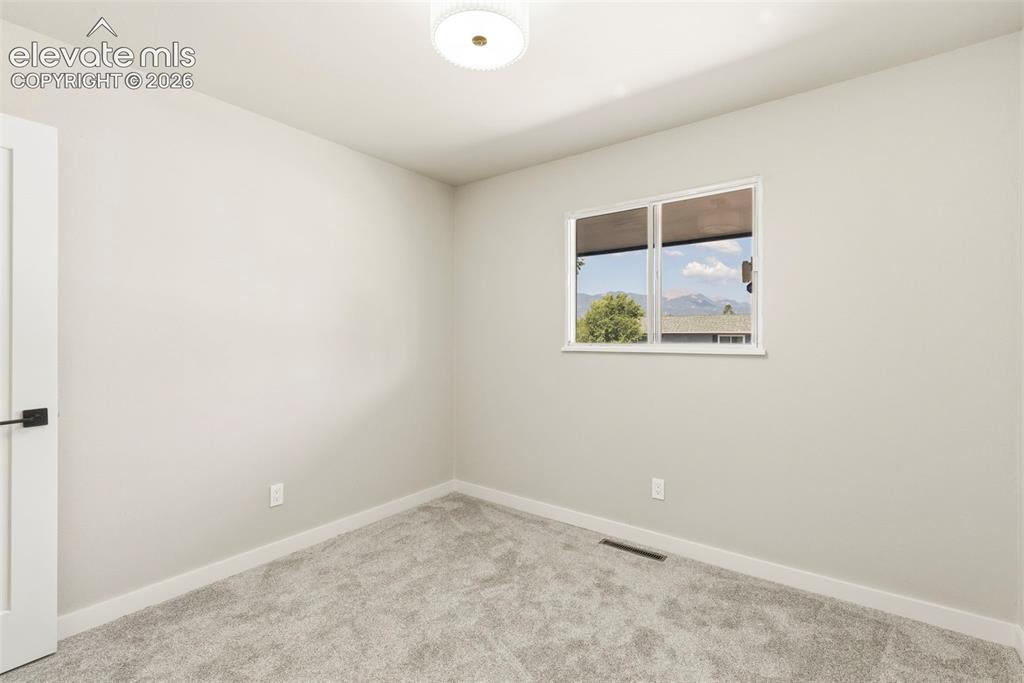 Image 33 of 46: Room featuring light taupe carpet, white baseboards, and neutral wall paint