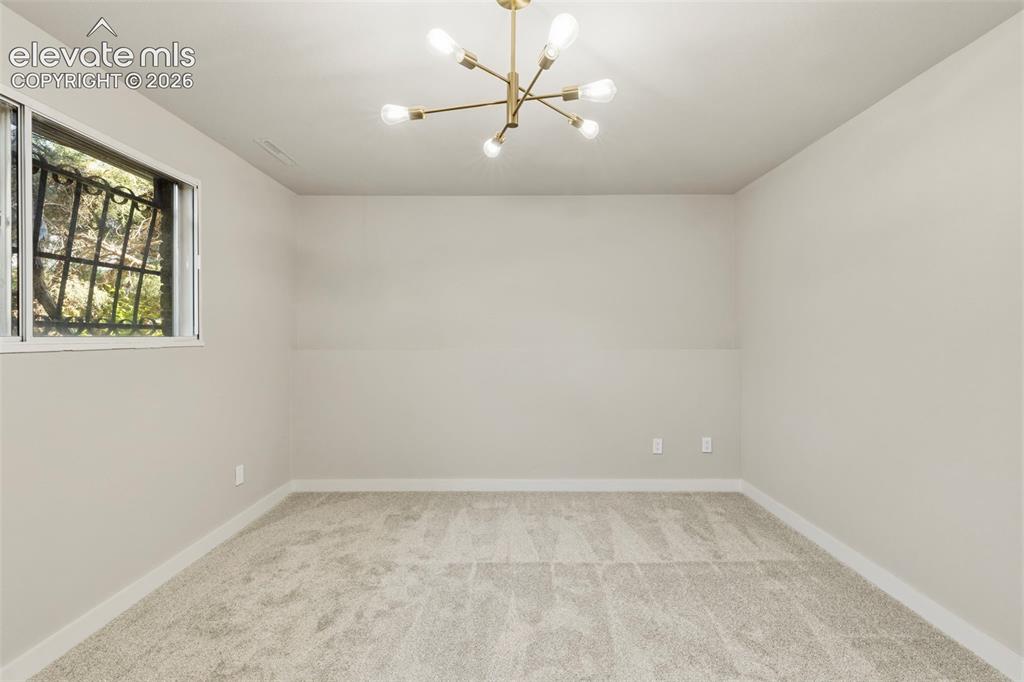 Image 35 of 46: Spacious room featuring new carpeting, a contemporary sputnik chandelier, a