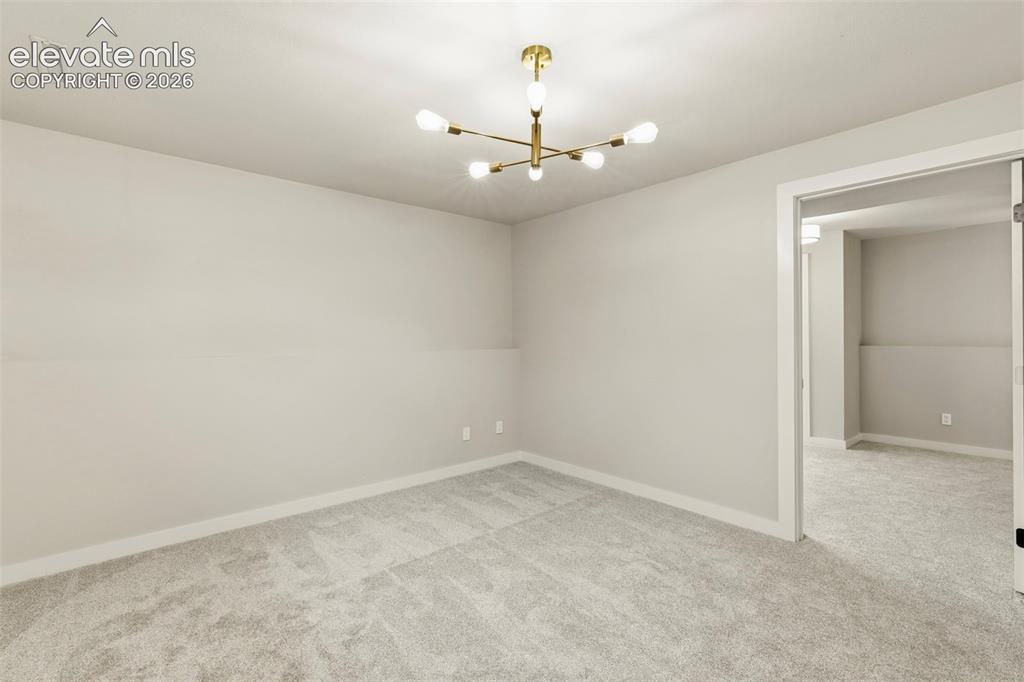 Image 36 of 46: Spacious room featuring light gray walls, new taupe carpeting, and white tr