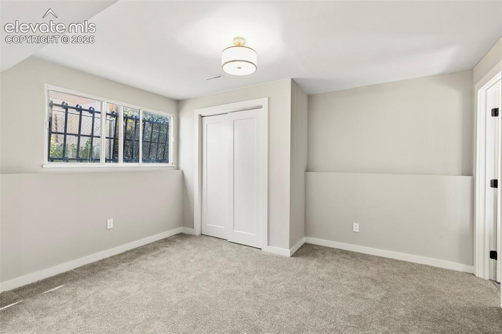 Image 40 of 46: Wall-to-wall taupe carpet flooring with a white trim baseboard