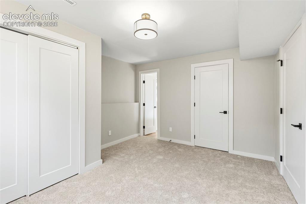Image 41 of 46: Plush taupe carpeting complements light grey walls