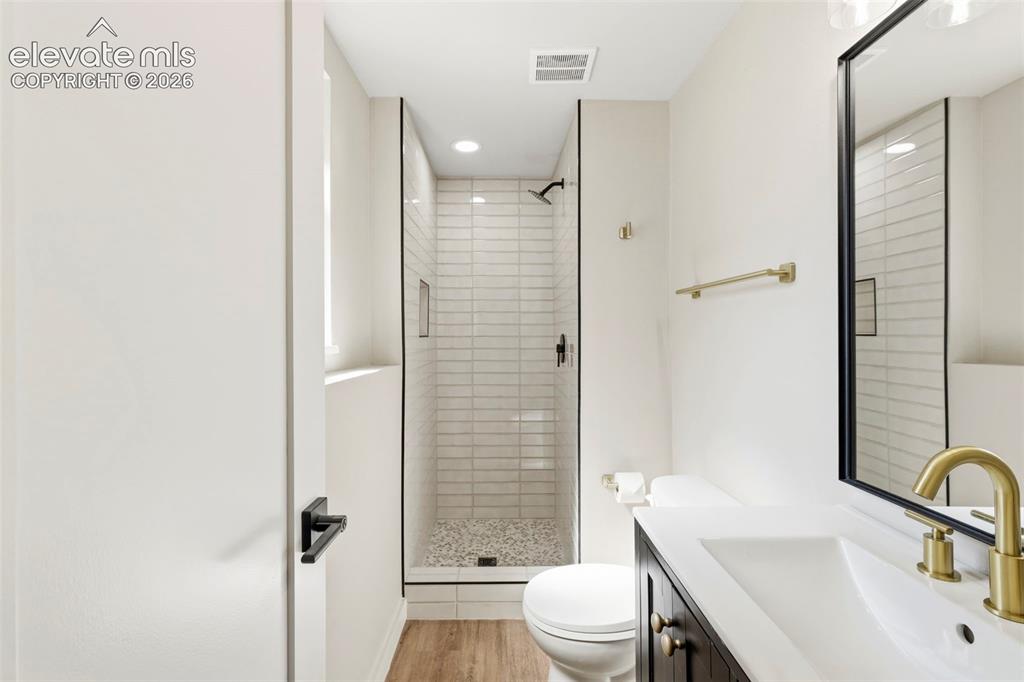 Image 44 of 46: Modern bathroom featuring a walk-in shower with subway tile surround, sleek