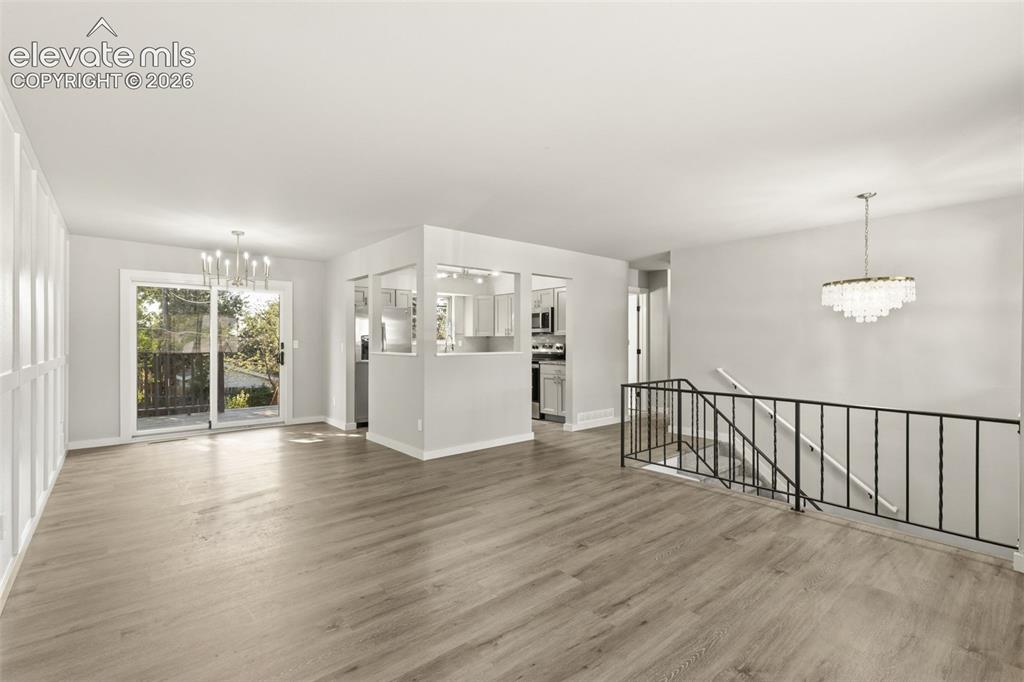 Image 9 of 46: Open living space featuring luxury vinyl plank flooring, a contemporary tie