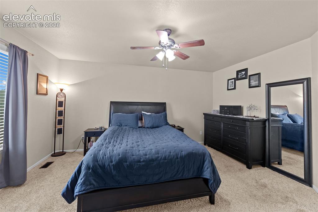Image 13 of 41: Recessed window with blinds, ceiling fan with integrated lighting, carpeted