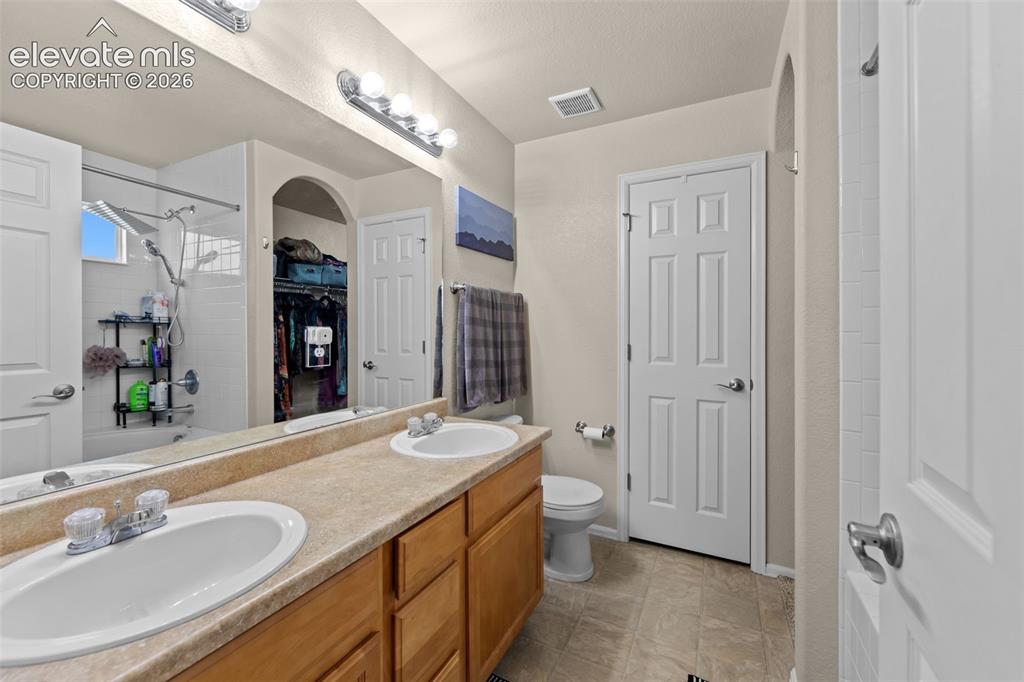 Image 15 of 41: Dual vanity with laminate countertops, two undermount sinks, and chrome fau