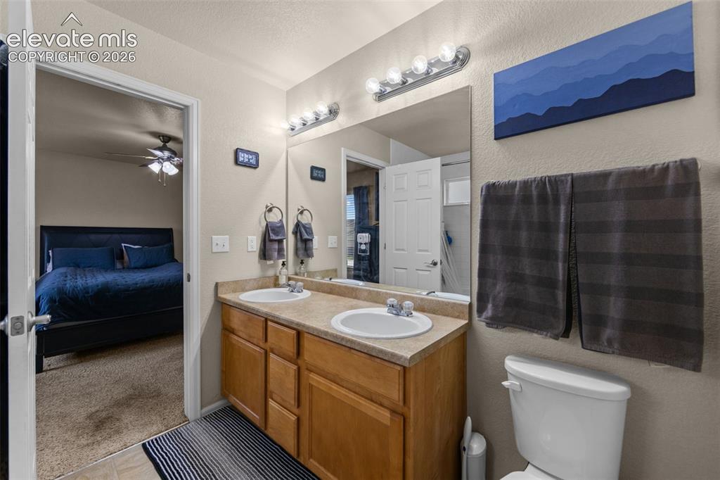 Image 17 of 41: Bathroom featuring a double vanity with integrated sinks, wood-finish cabin