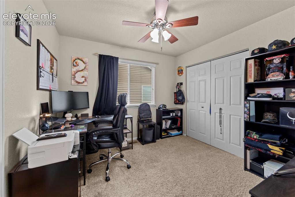 Image 19 of 41: Neutral-toned walls, textured carpeting, window with horizontal blinds, and