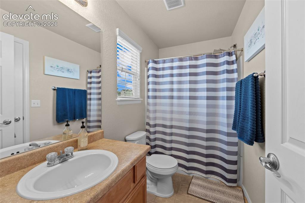 Image 21 of 41: Bathroom featuring a single vanity with an integrated sink, a built-in mirr