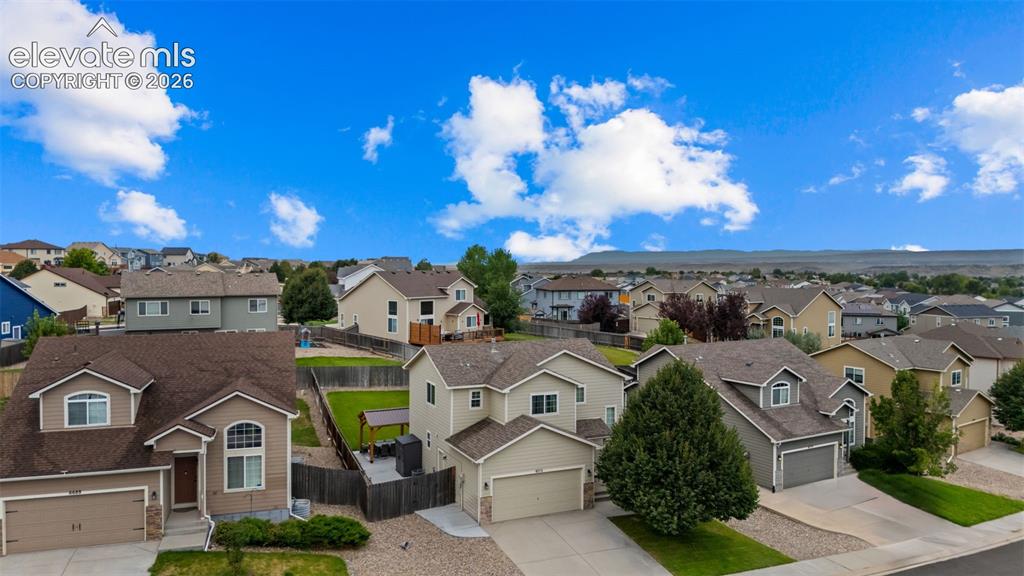 Image 36 of 41: Aerial perspective featuring residential homes, paved driveways, and landsc