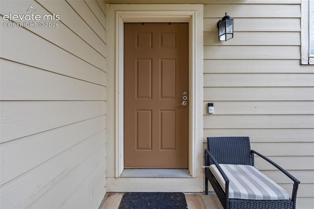 Image 4 of 41: Panel-style entry door with a multi-pane exterior light fixture
