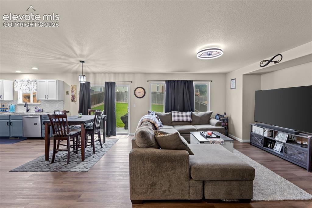 Image 5 of 41: Open-concept living space featuring wood-finish flooring, recessed lighting