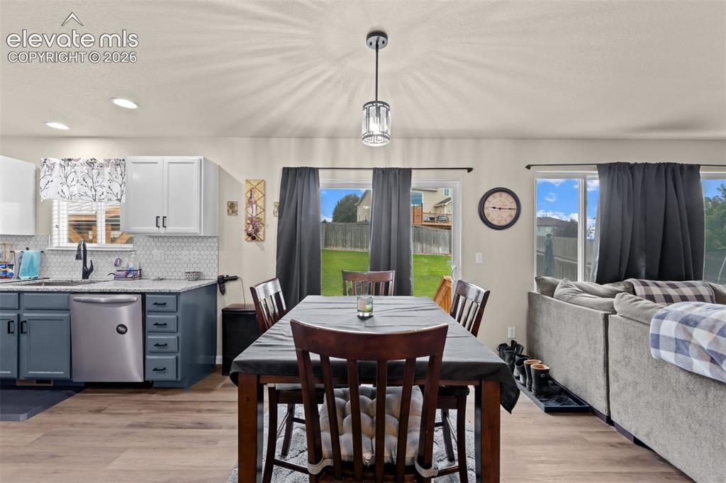 Image 7 of 41: Open-concept living space with wood-finish flooring, recessed lighting, and