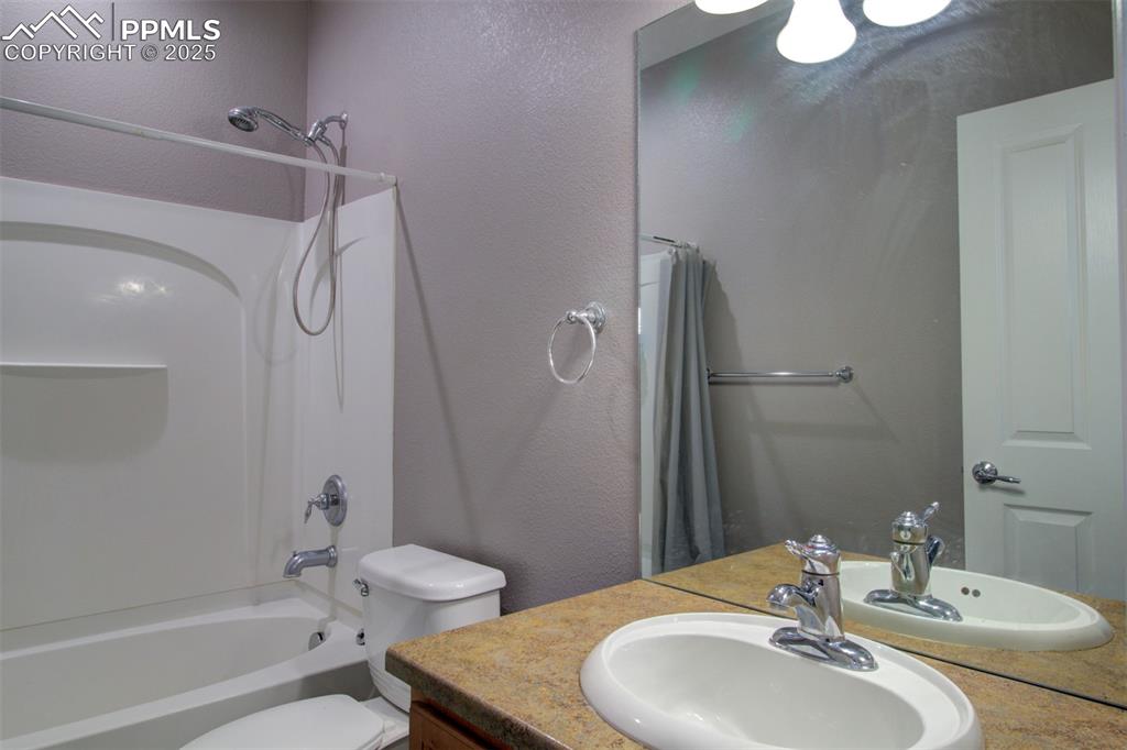 Image 21 of 21: Bathroom with vanity, shower / bath combo, and a textured wall