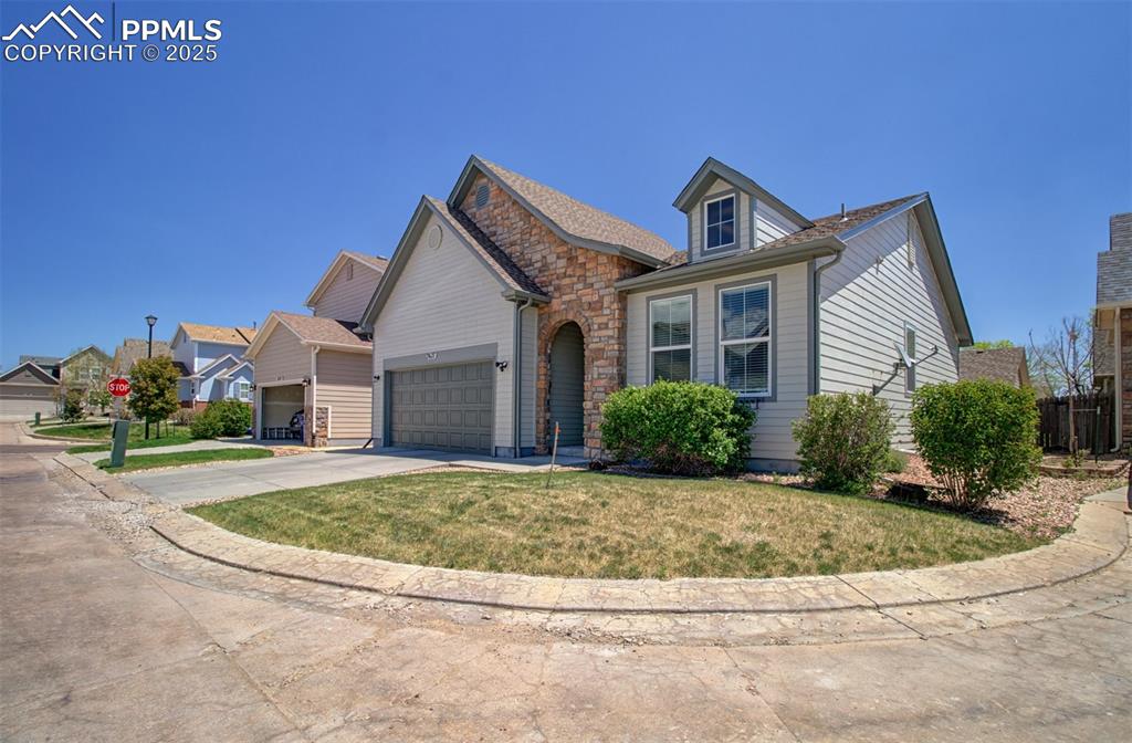 Image 3 of 21: Traditional-style house featuring concrete driveway, a garage, a front lawn