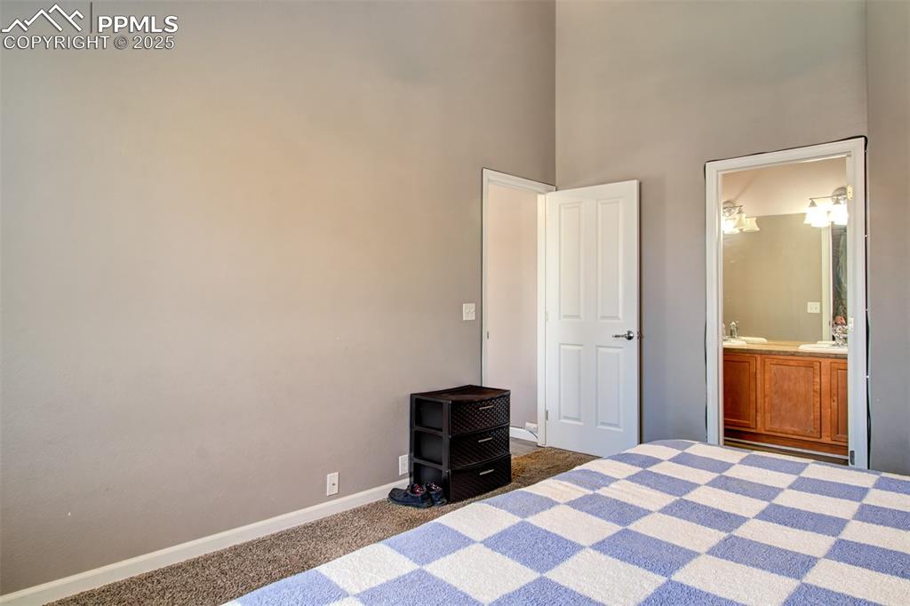 Image 8 of 21: Unfurnished bedroom with carpet, a high ceiling, and connected bathroom