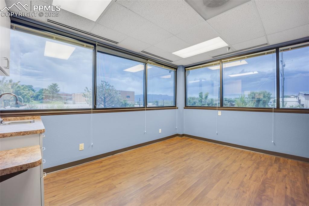 Image 25 of 49: Empty room featuring light wood finished floors and a paneled ceiling