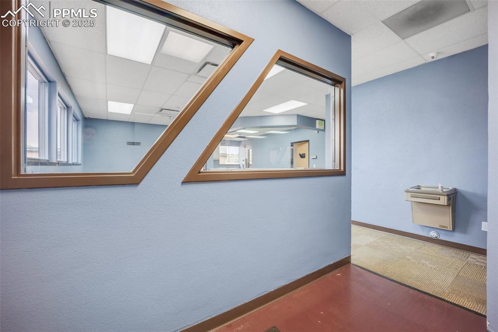 Image 38 of 49: Corridor with a drop ceiling and baseboards