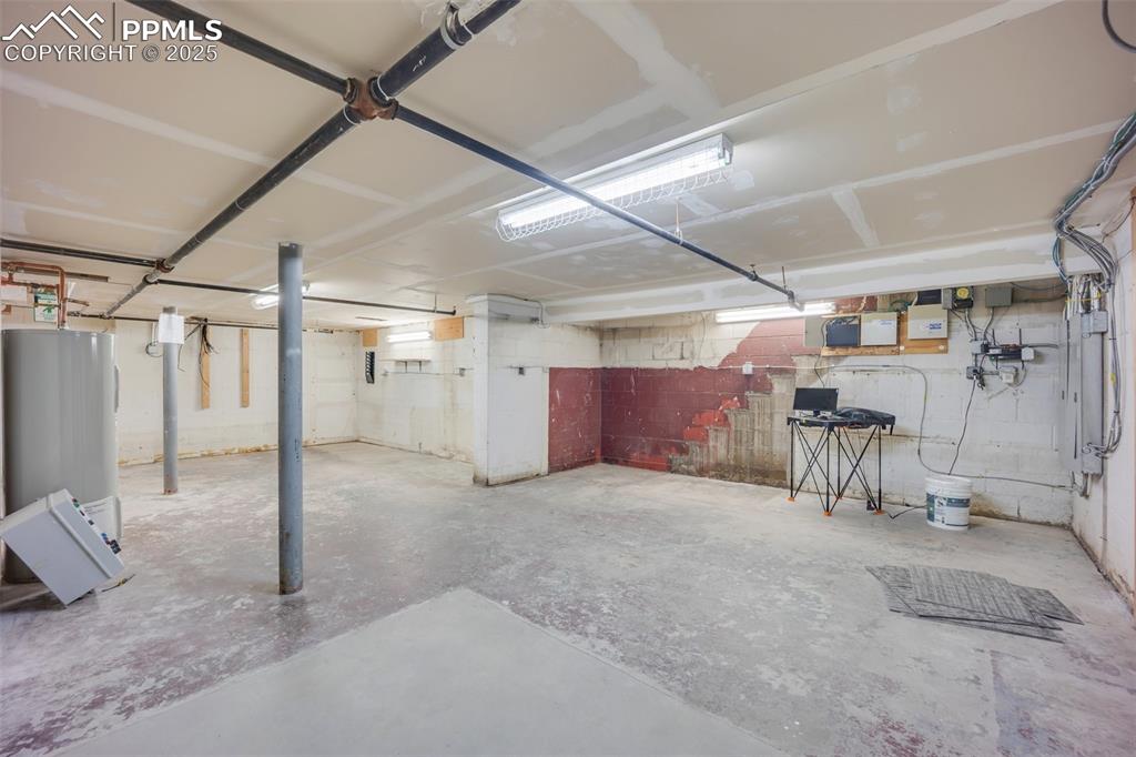 Image 43 of 49: Unfinished below grade area featuring electric water heater