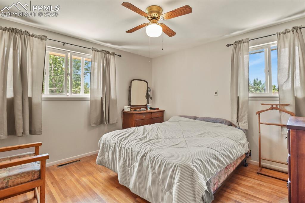 Image 12 of 30: Bedroom featuring wood finished floors and a ceiling fan