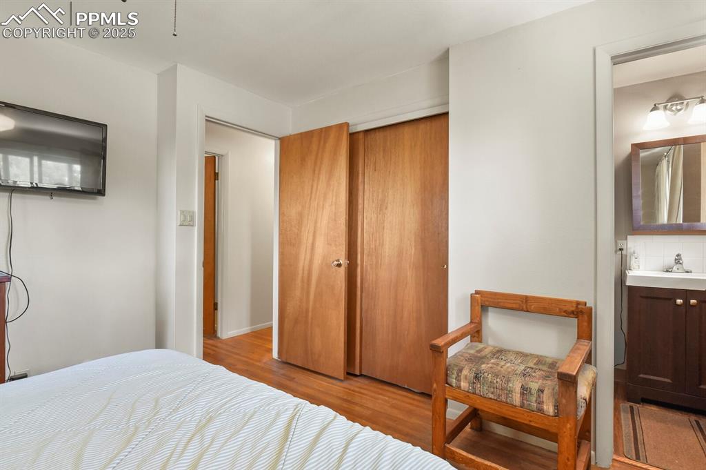 Image 13 of 30: Bedroom with wood finished floors, a closet, and ensuite bathroom