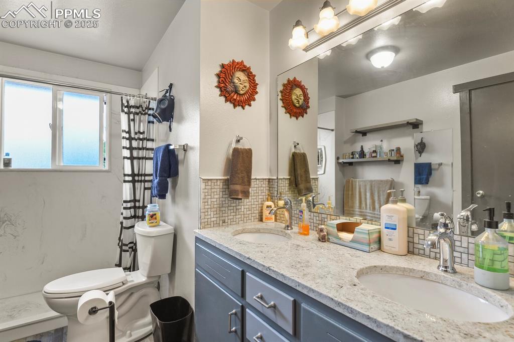 Image 15 of 30: Full bath with backsplash, double vanity, and a shower with curtain