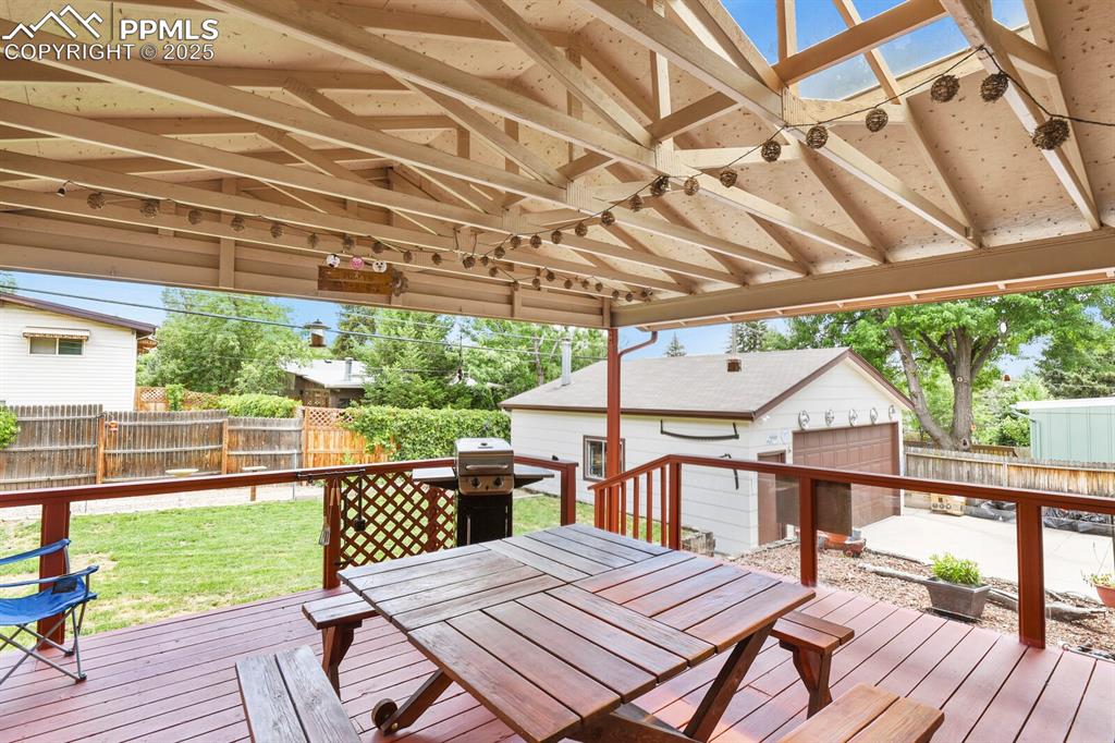 Image 22 of 30: Wooden deck featuring a fenced backyard, an outbuilding, outdoor dining spa