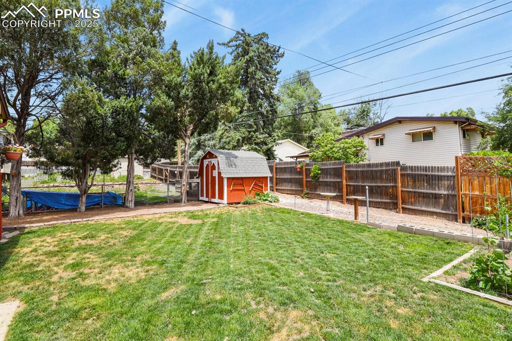 Image 24 of 30: Fenced backyard featuring a storage shed