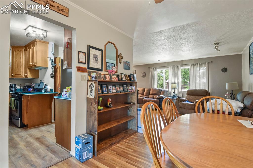 Image 8 of 30: Dining room featuring light wood-style floors, ornamental molding, and a te