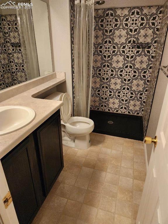 Image 11 of 17: Bathroom with a stall shower and vanity