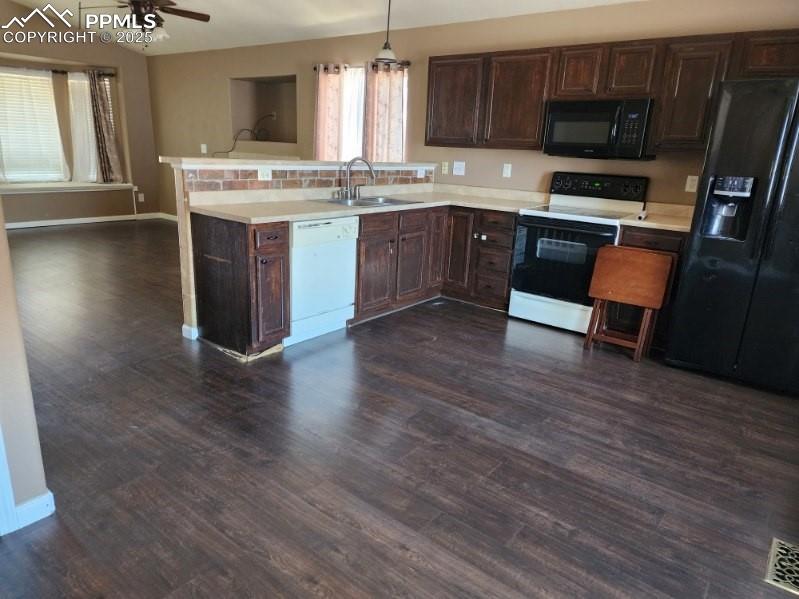 Image 9 of 17: Kitchen featuring dark brown cabinets, black appliances, light countertops,