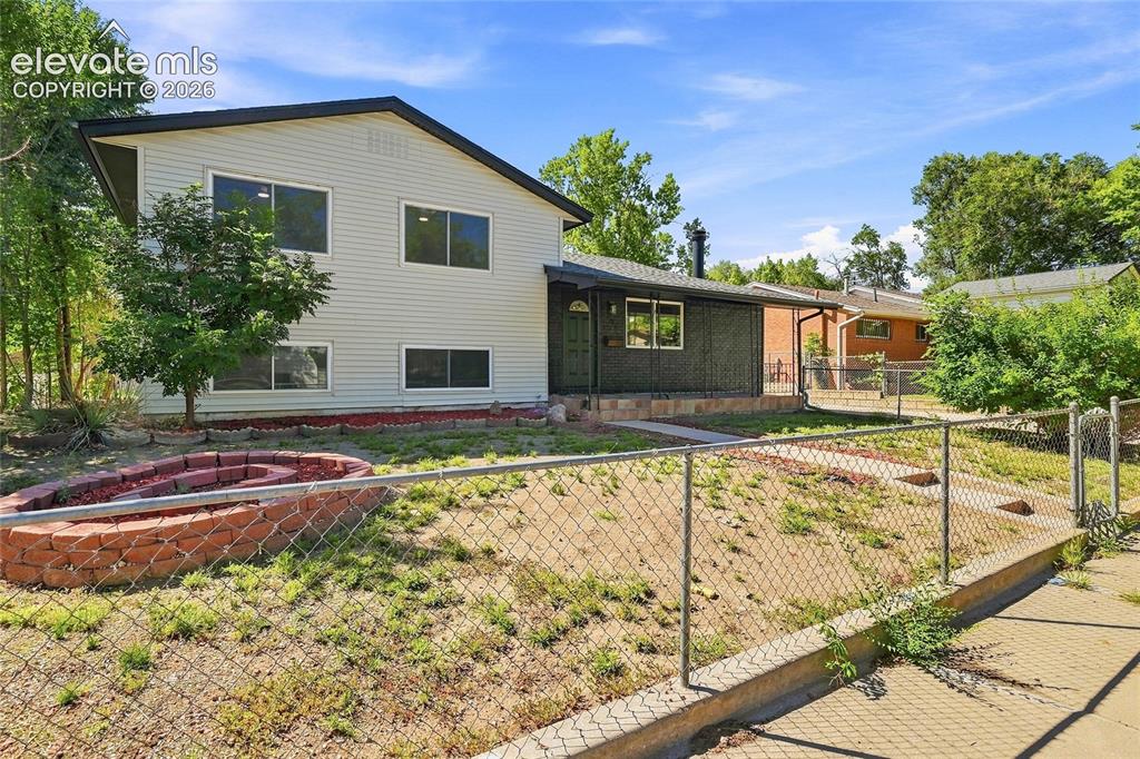Image 1 of 30: Two-story residence featuring light-colored siding, multiple windows, a dar