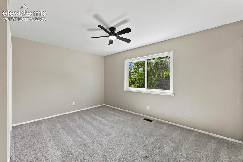 Image 12 of 30: Recessed lighting, ceiling fan, neutral wall tones, window with natural lig