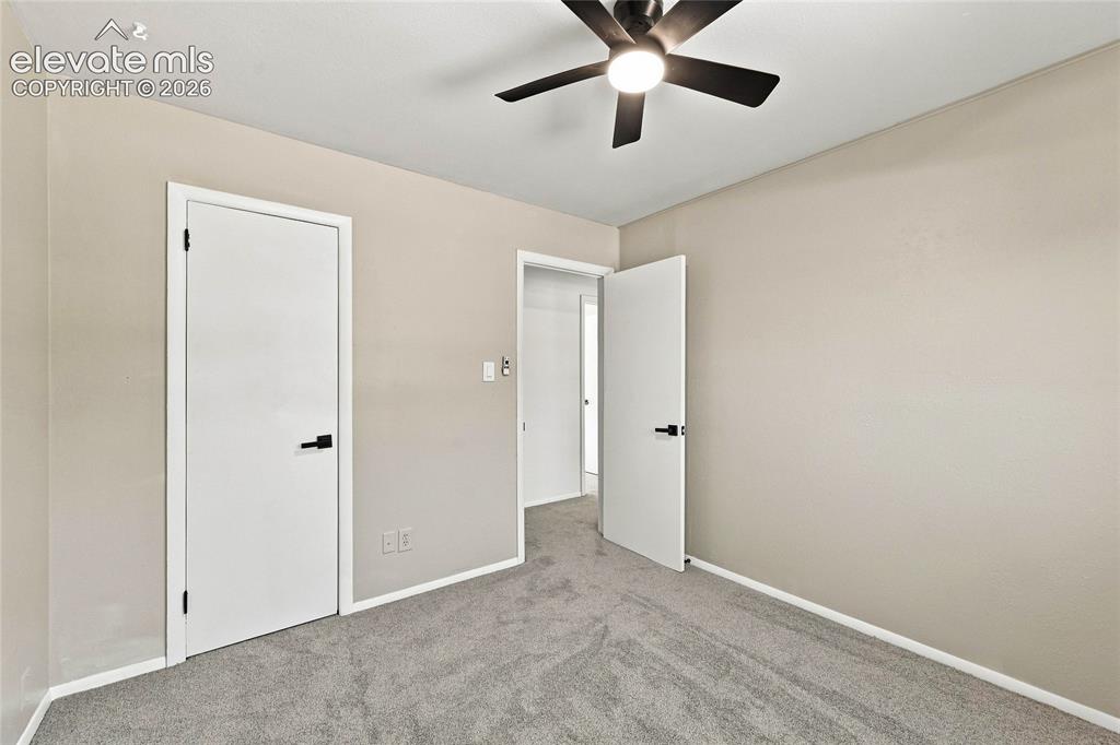 Image 19 of 30: Plush gray carpeting, neutral wall palette, modern ceiling fan with integra