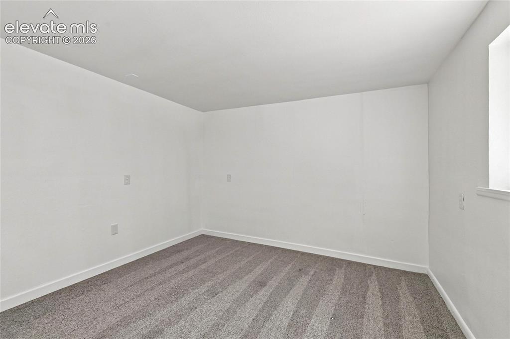 Image 24 of 30: Neutral wall color, wall-to-wall carpeting, and a single window