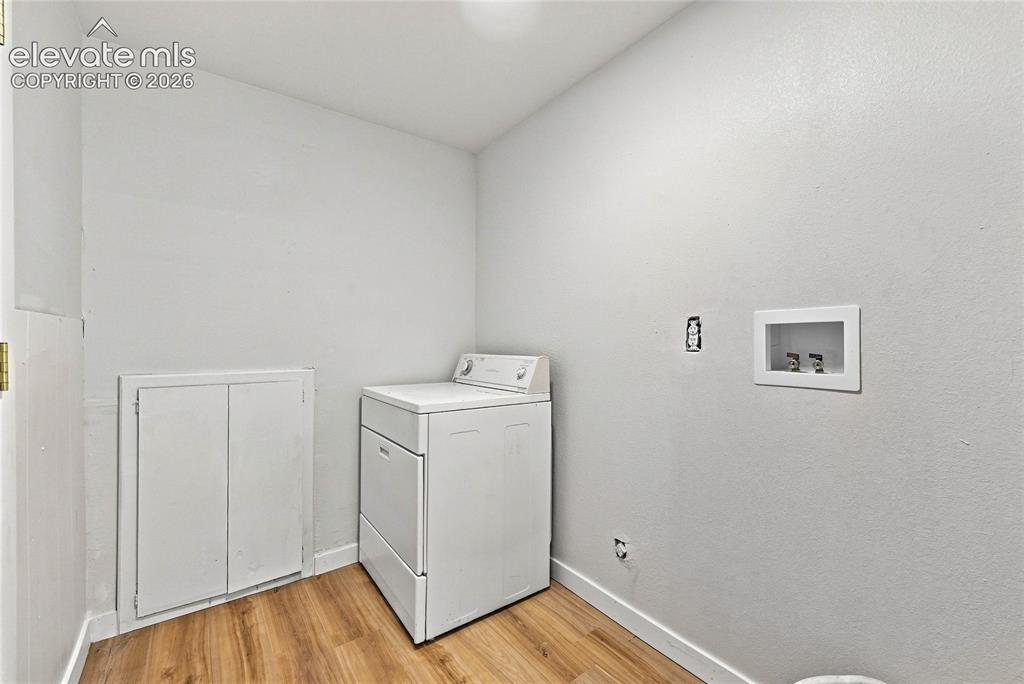 Image 26 of 30: Wood-finish flooring with white wall finishes