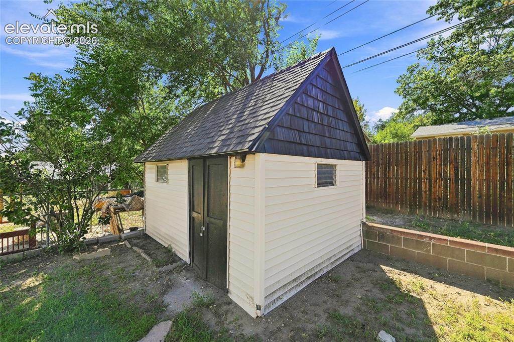 Image 28 of 30: Outdoor storage shed featuring a gabled roof with dark shingles, horizontal