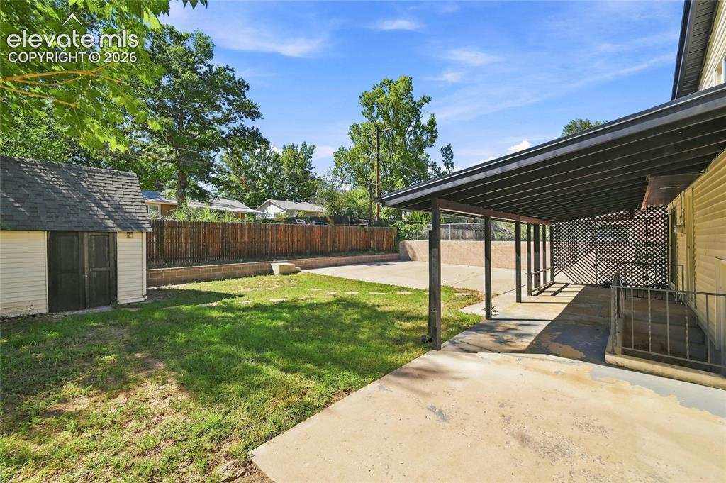 Image 29 of 30: Expansive backyard featuring a storage shed, concrete patio, covered outdoo