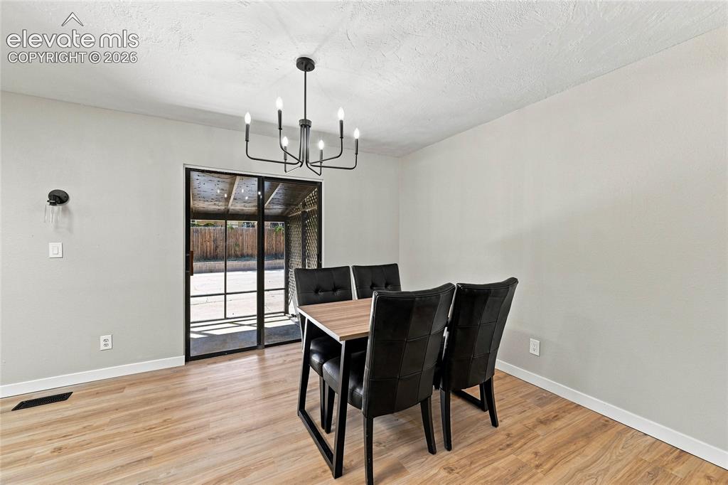 Image 6 of 30: Wood-finish flooring, light gray walls, black framed sliding glass door, mo