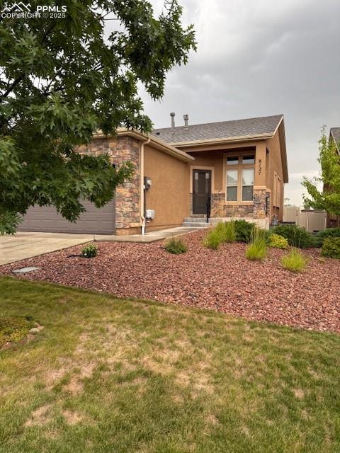 Image 3 of 37: View of front facade featuring stucco siding, stone siding, concrete drivew