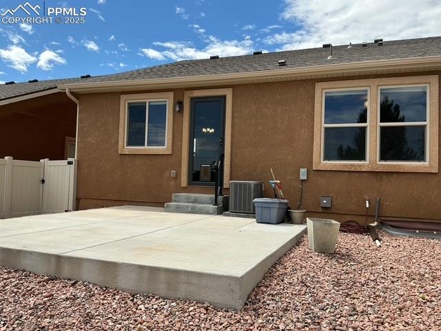 Image 4 of 37: Back of property with a patio, a shingled roof, and stucco siding